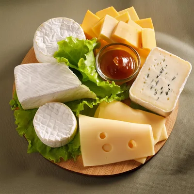 Assorted Cheese Platter With Honey On Wooden Board
