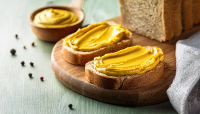 Mustard Spread On Slices Of Whole Grain Bread