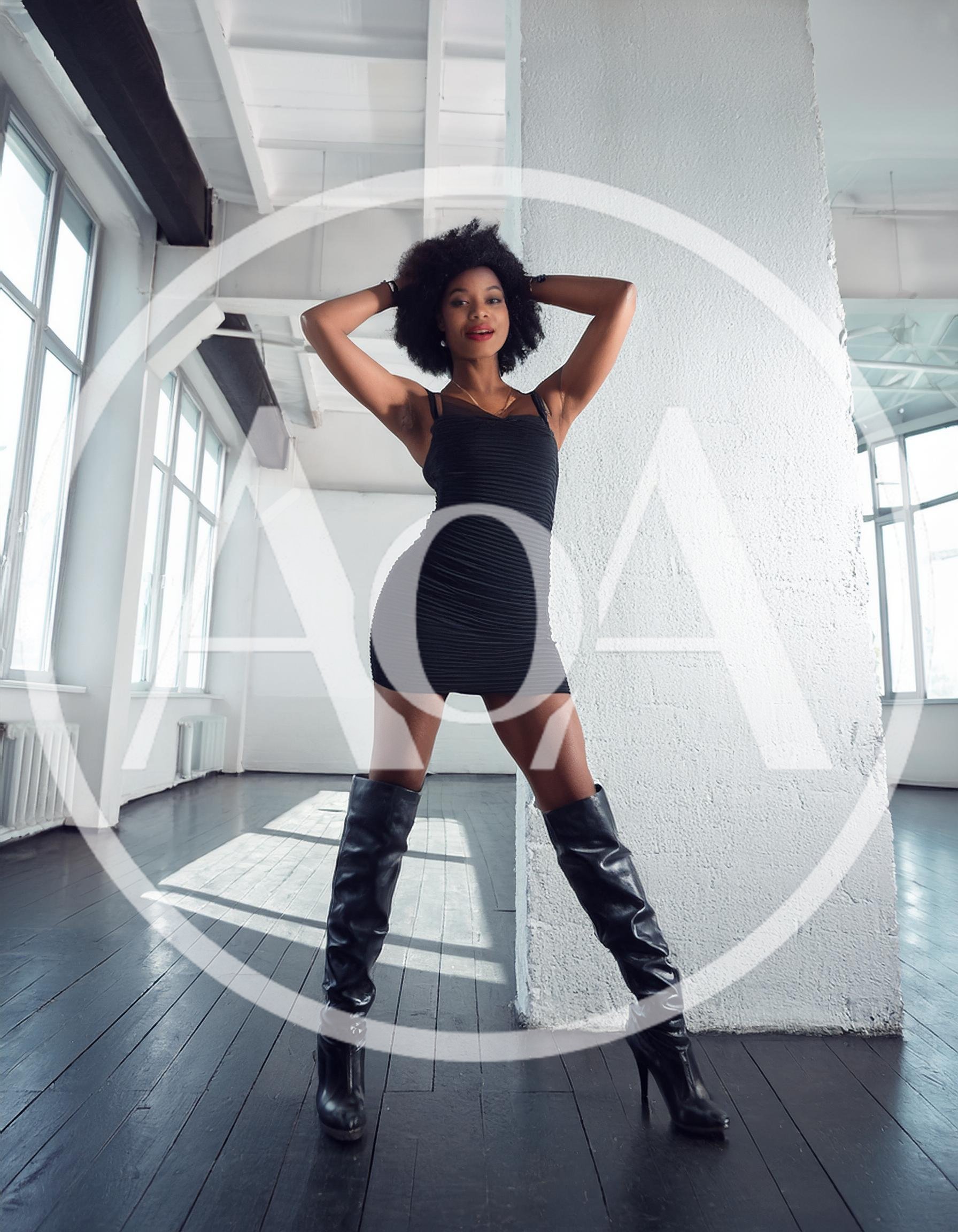 Stylish Woman Posing In Black Dress And High Boots