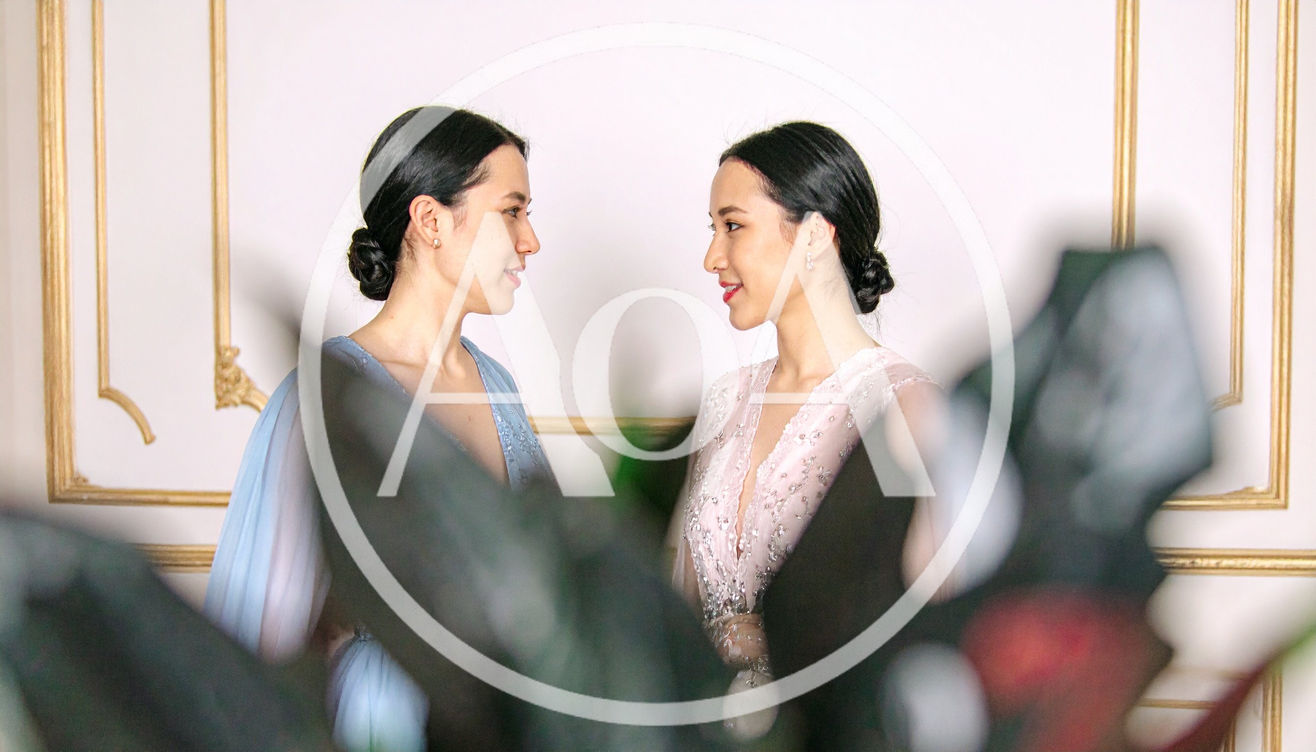 Two Elegant Women In Evening Gowns Looking At Each Other