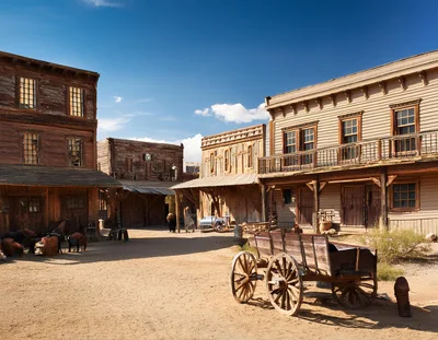 Old West Town Street With Wooden Buildings And Wagon
