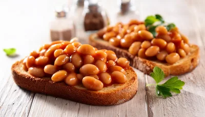 Two Slices Of Toast Topped With Baked Beans