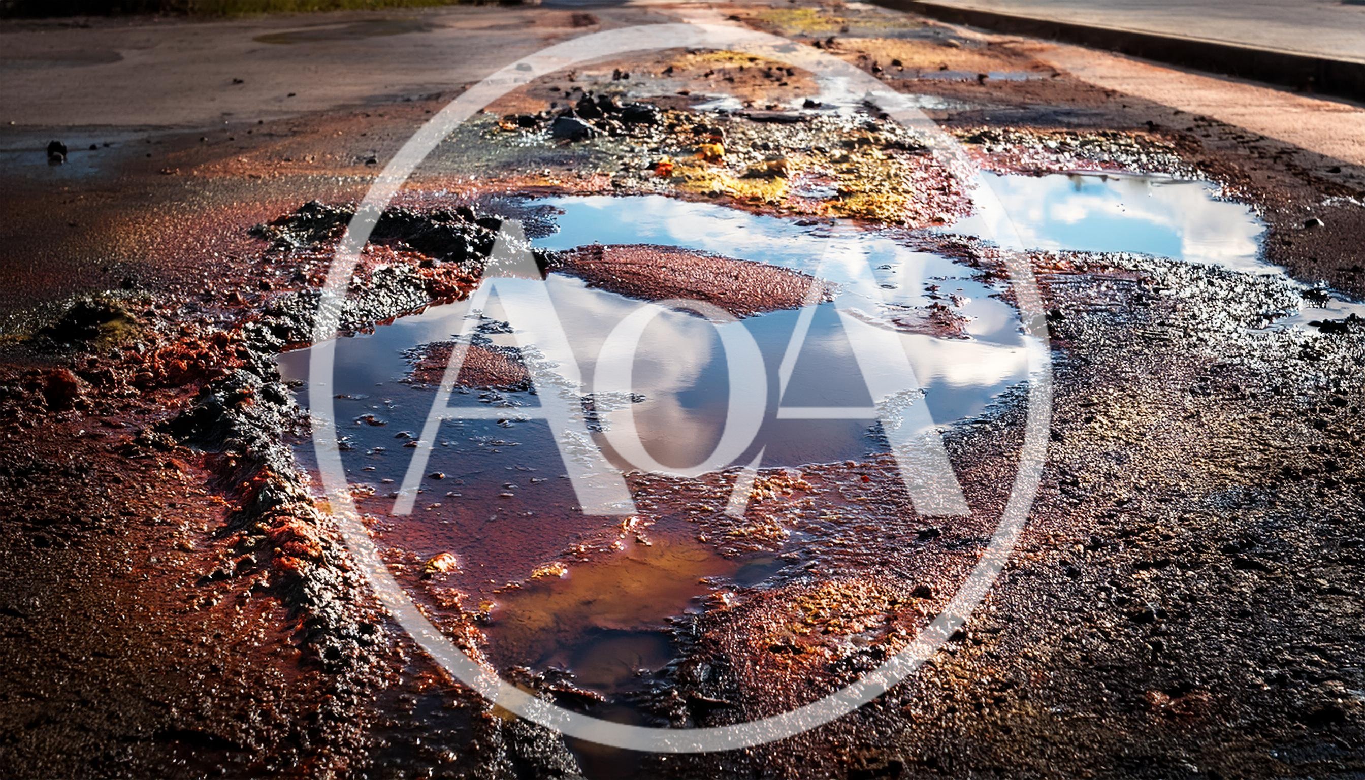 Large Pothole Filled With Rainwater On Damaged Asphalt Road