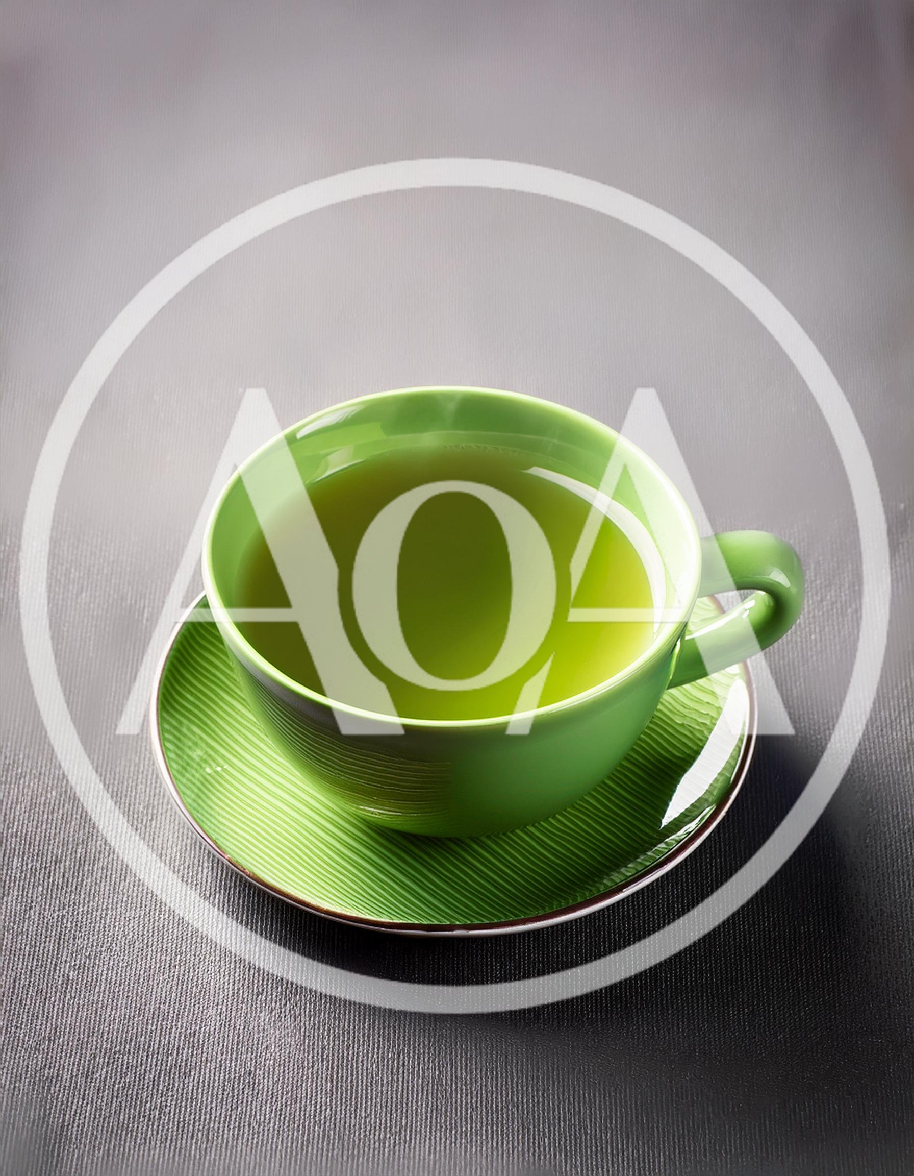 Green Tea Cup On A Textured Saucer