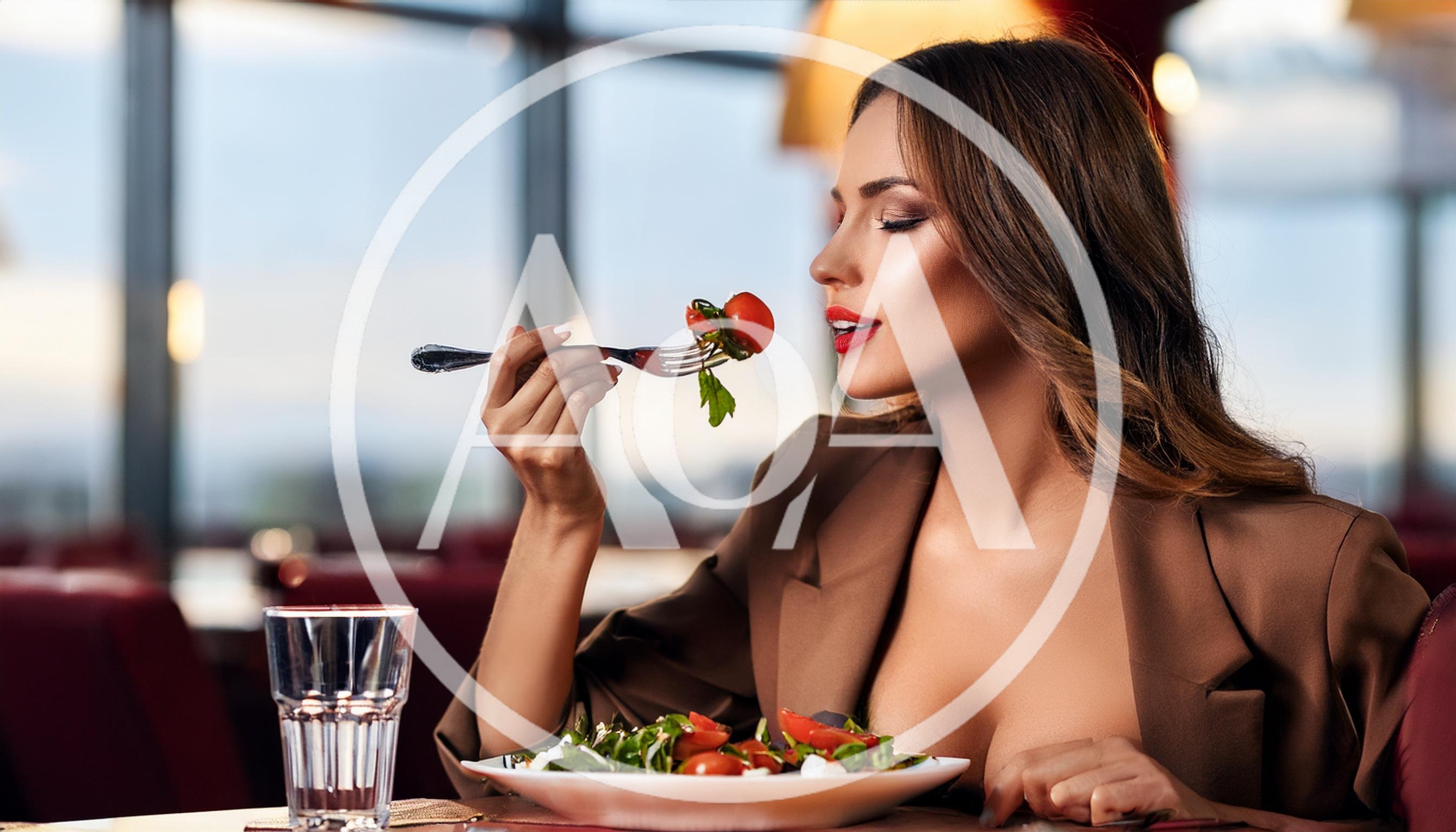 Elegant Woman Eating Fresh Salad In A Restaurant