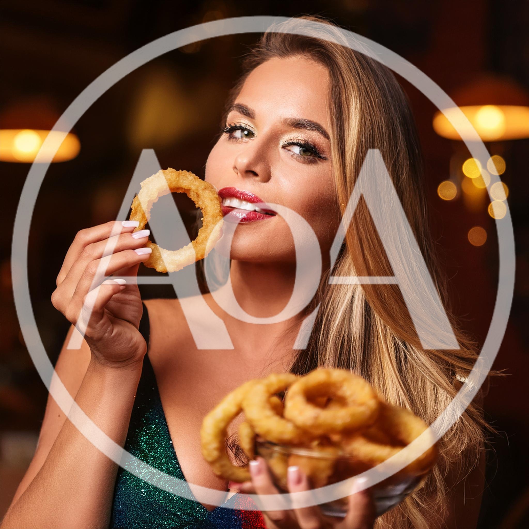 Beautiful Woman Eating Crispy Onion Rings In Restaurant