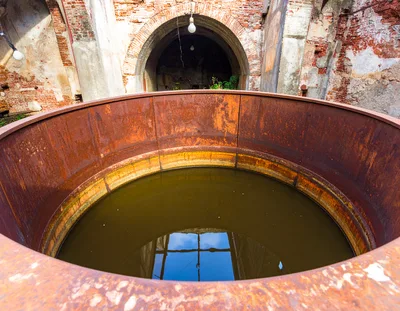 Large Rusty Metal Vat In Abandoned Brick Building