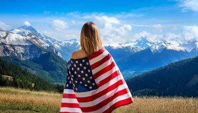 Woman Standing With American Flag Overlooking Mountain Range