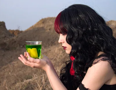 Gothic Woman Holding A Glass Of Green Liquid