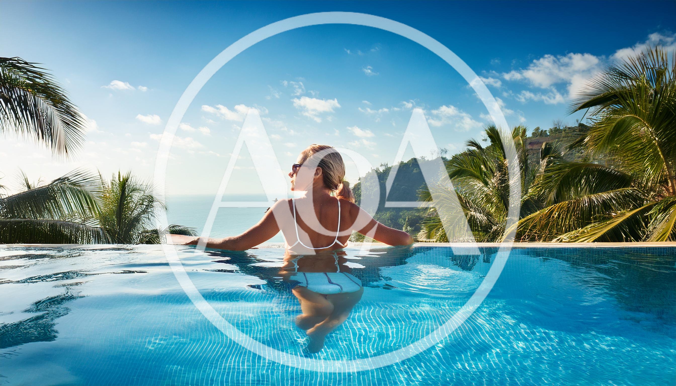 Woman Relaxing In Tropical Infinity Pool