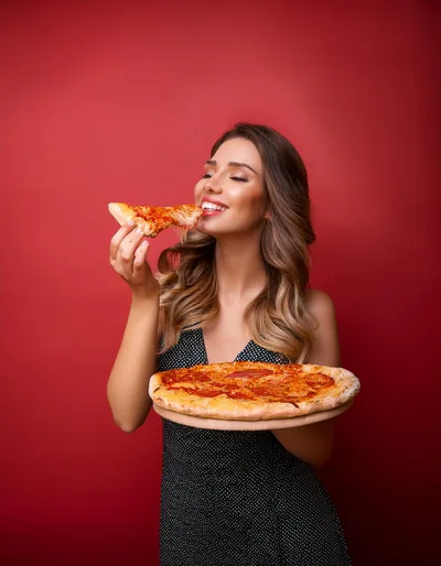 Beautiful Woman Eating A Slice Of Pizza