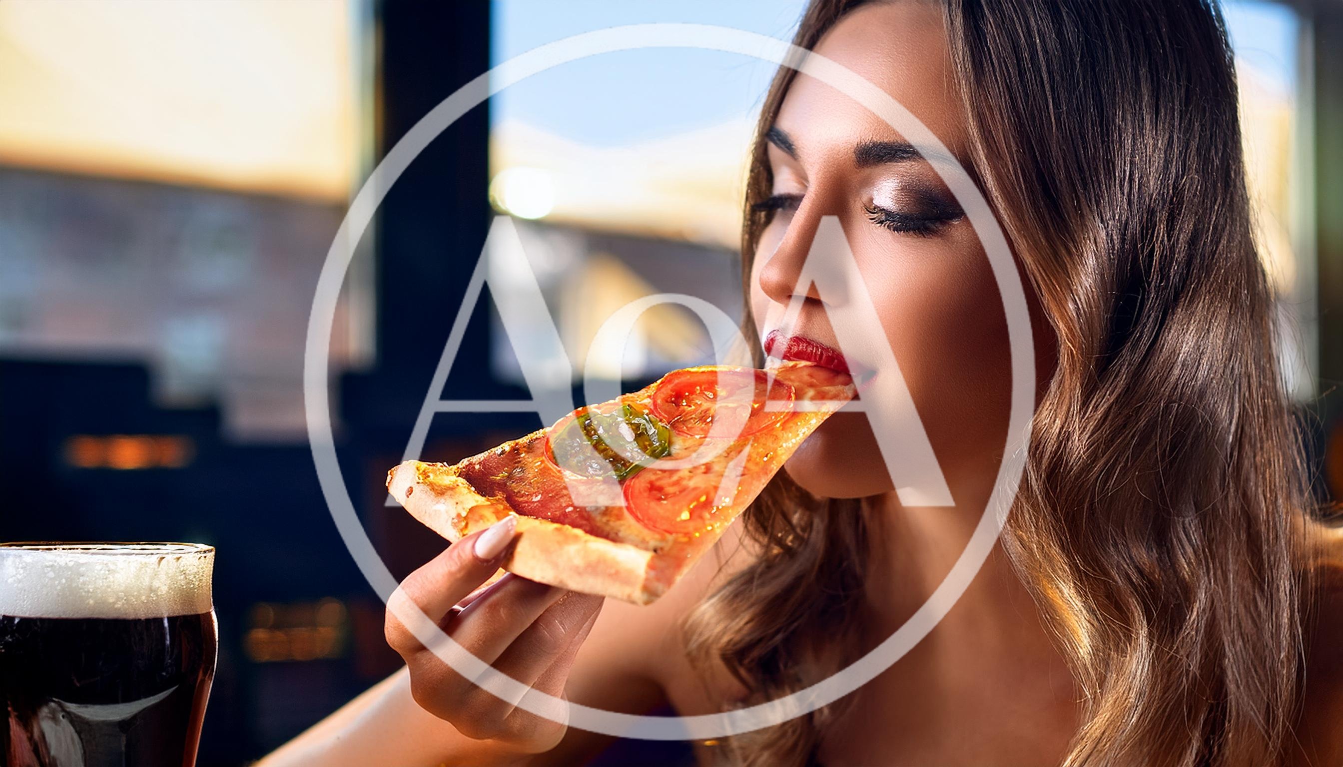 Young Woman Eating A Slice Of Pizza