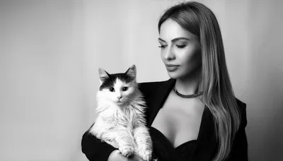 Elegant Woman Holding A Fluffy Cat In Studio