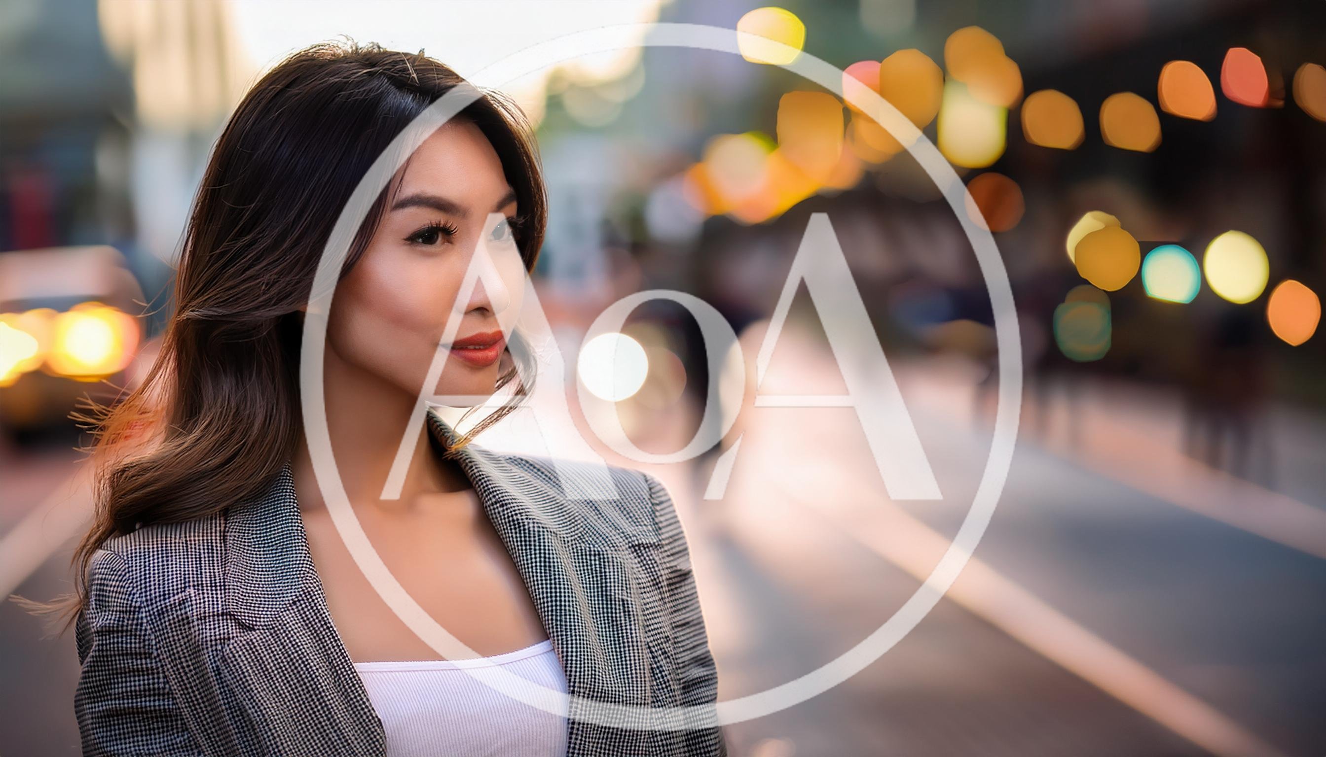 Young Asian Woman Standing On City Street At Dusk