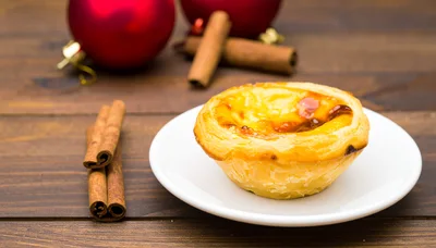 Portuguese Egg Tart With Cinnamon Sticks On Wooden Table