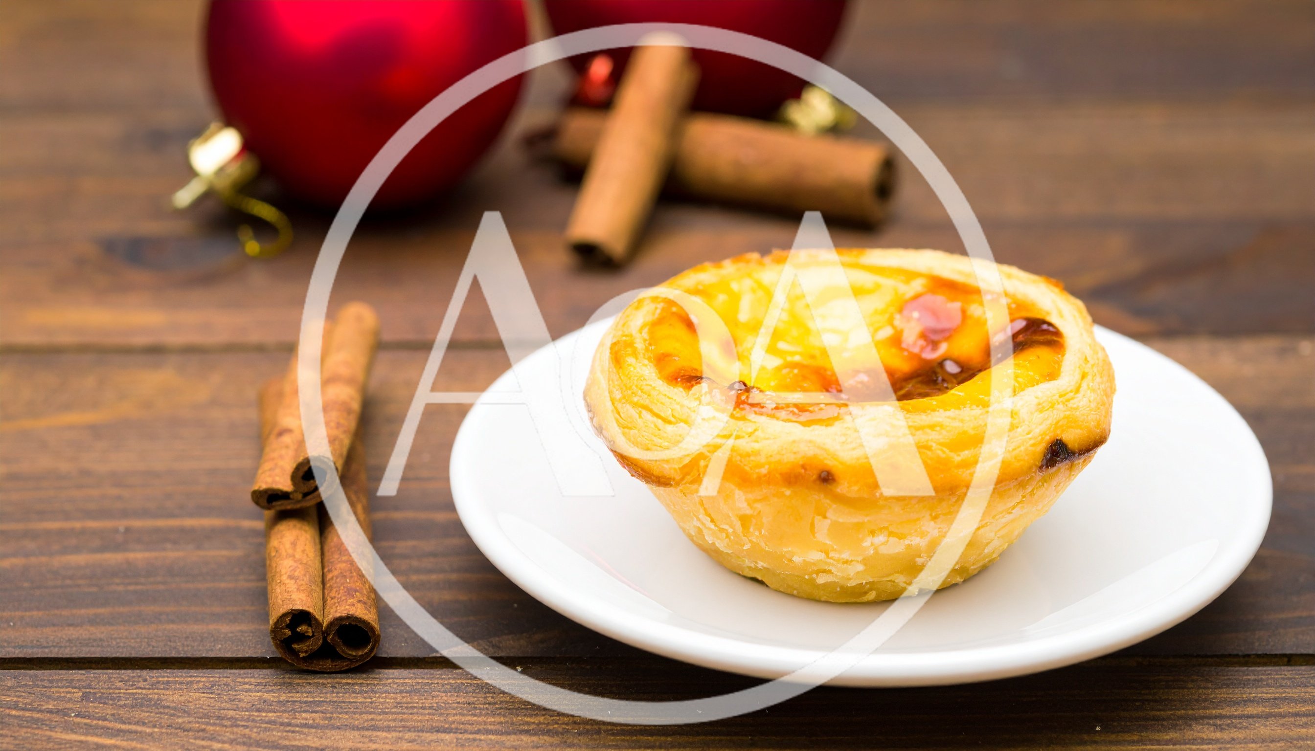 Portuguese Egg Tart With Cinnamon Sticks On Wooden Table
