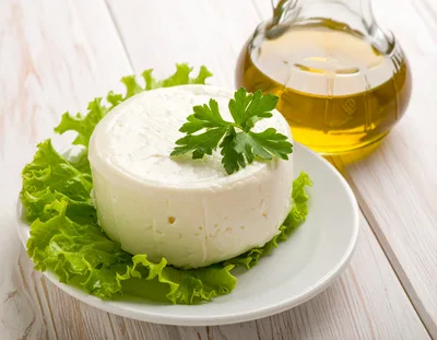 Fresh Round Cheese Wheel With Lettuce And Olive Oil
