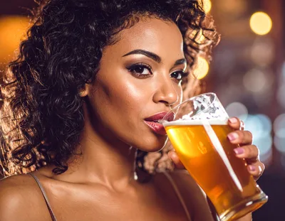 Beautiful Woman Drinking Beer at a Nightclub