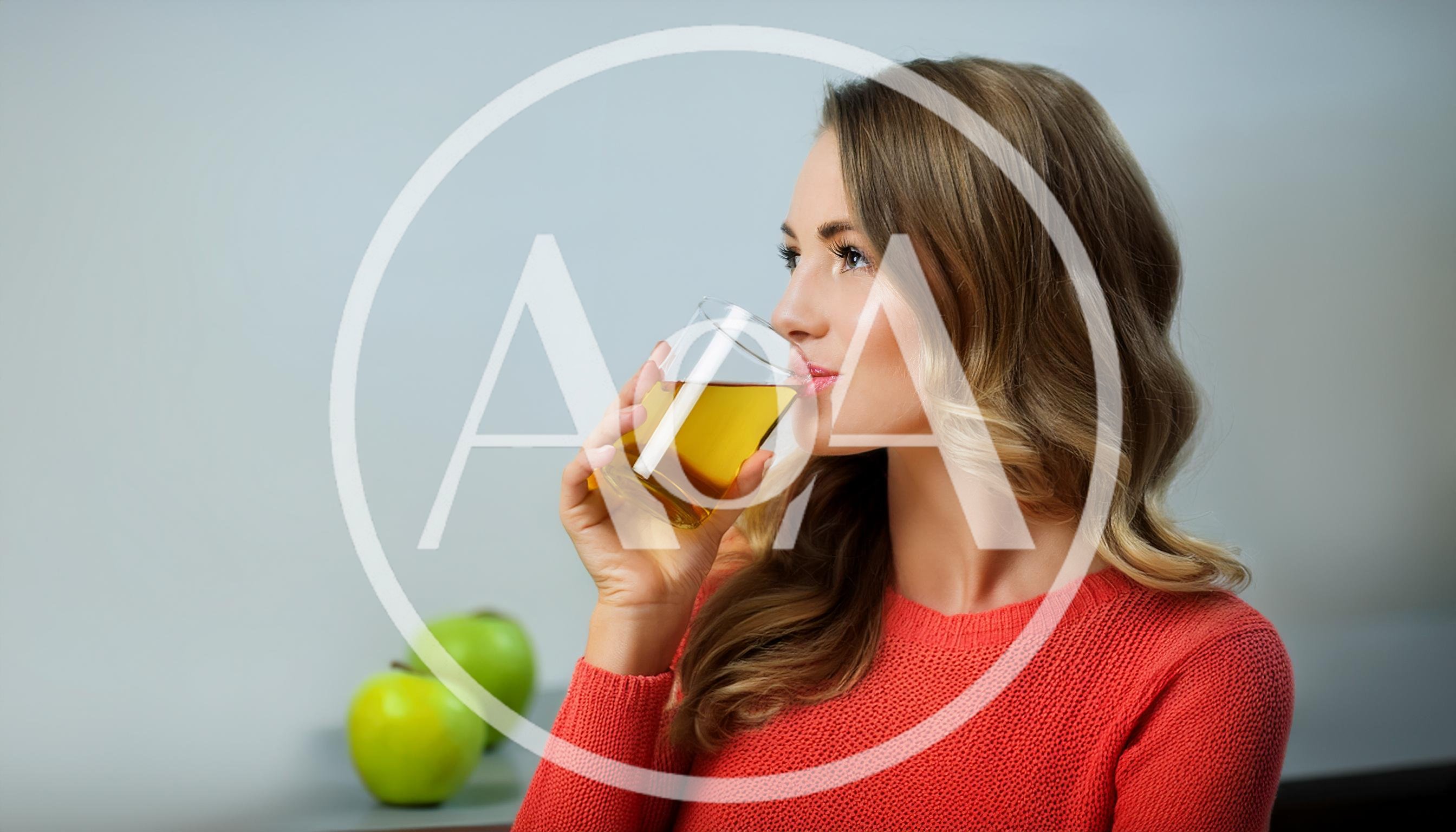 Young Woman Drinking Apple Juice With Green Apples