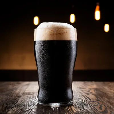 Cold Pint Of Dark Stout Beer On Wooden Table