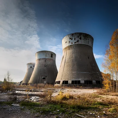 Abandoned Industrial Cooling Towers In A Desolate Landscape