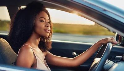Young Black Woman Driving A Car At Sunset
