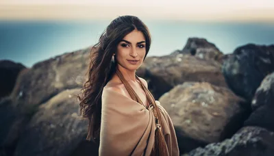 Portrait Of A Beautiful Woman Standing On Rocky Coast