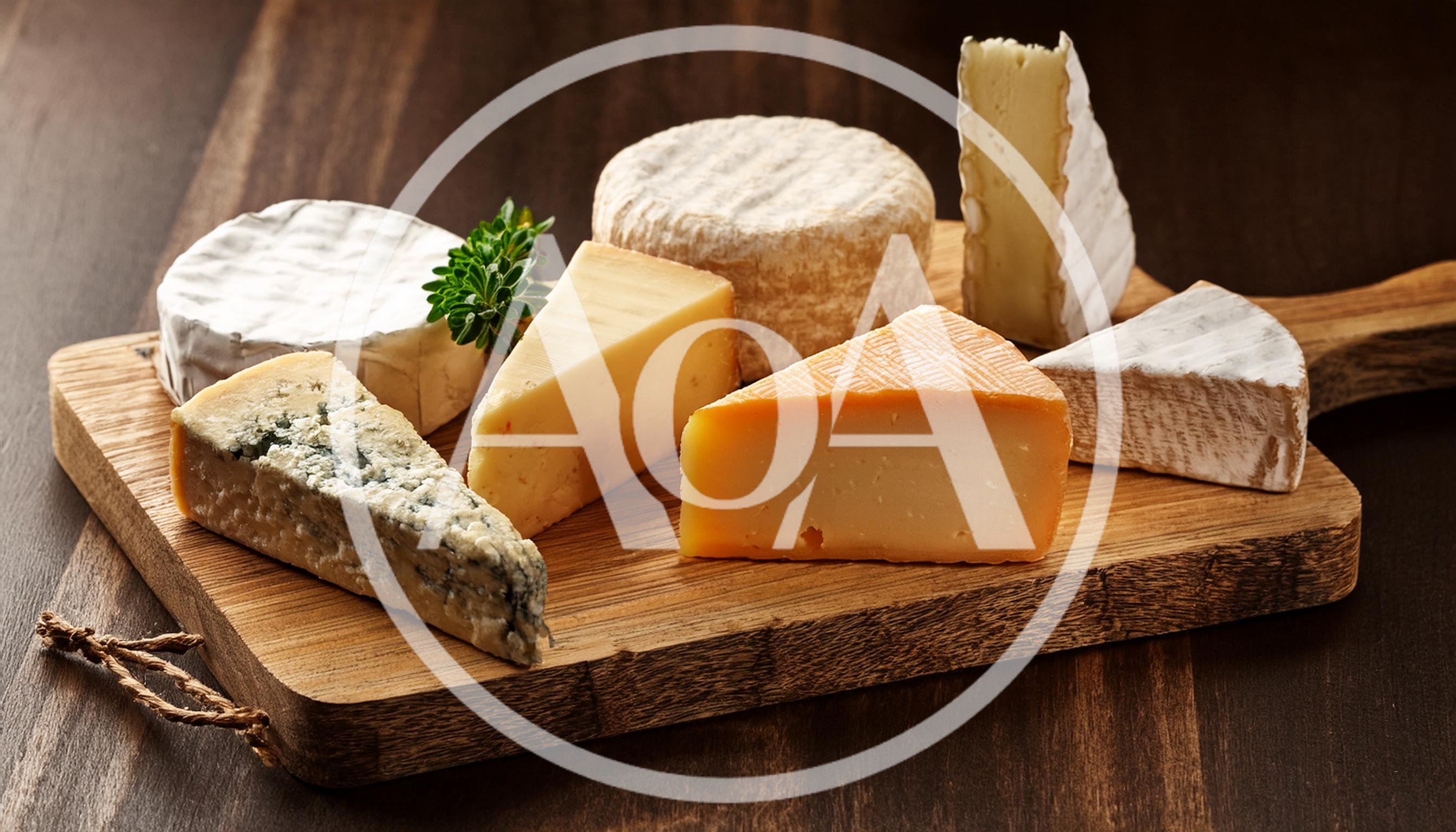 Assorted Gourmet Cheeses Arranged On A Wooden Board
