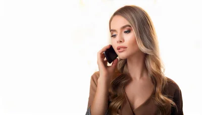 Young Woman Talking On Smartphone Against White Background