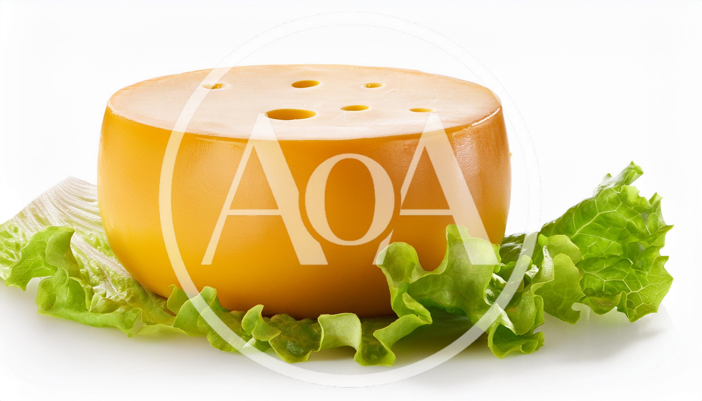 Round Wheel Of Yellow Cheese On Fresh Lettuce Leaves