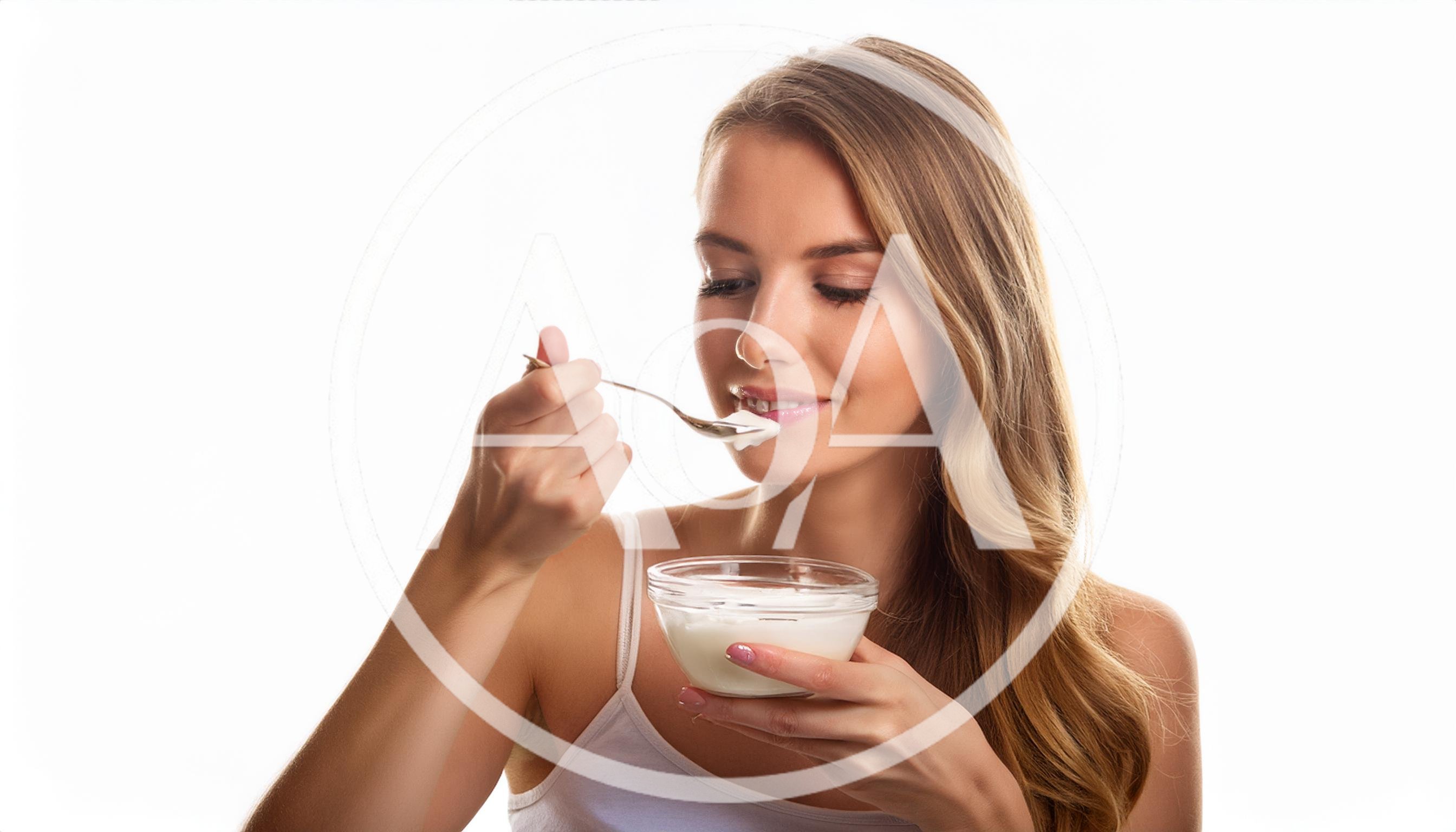 Young Woman Eating Yogurt From A Glass Bowl