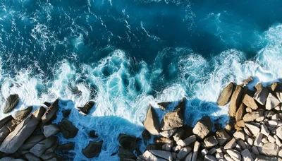 Aerial View Of Ocean Waves Crashing Against Rocky Shore