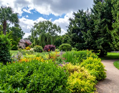 Lush Garden Landscape With A Stone Cottage