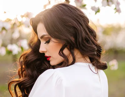 Beautiful Woman With Long Wavy Hair In Spring Orchard