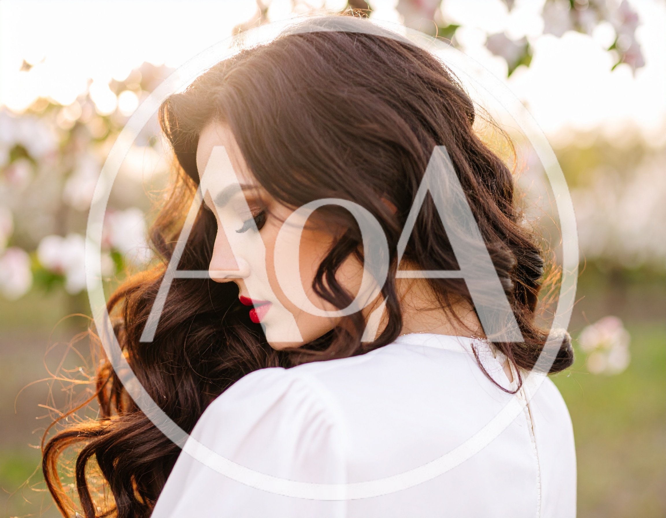 Beautiful Woman With Long Wavy Hair In Spring Orchard