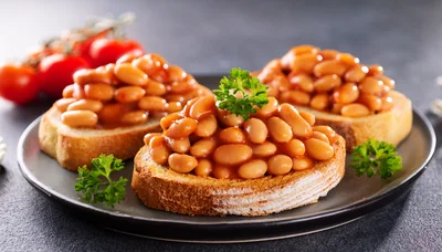 Three Slices Of Toast Topped With Baked Beans