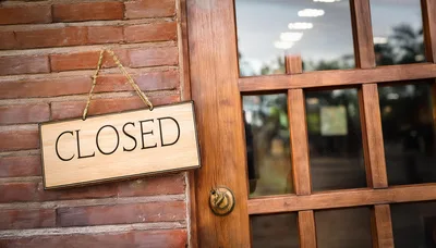 Closed Sign Hanging On A Wooden Door
