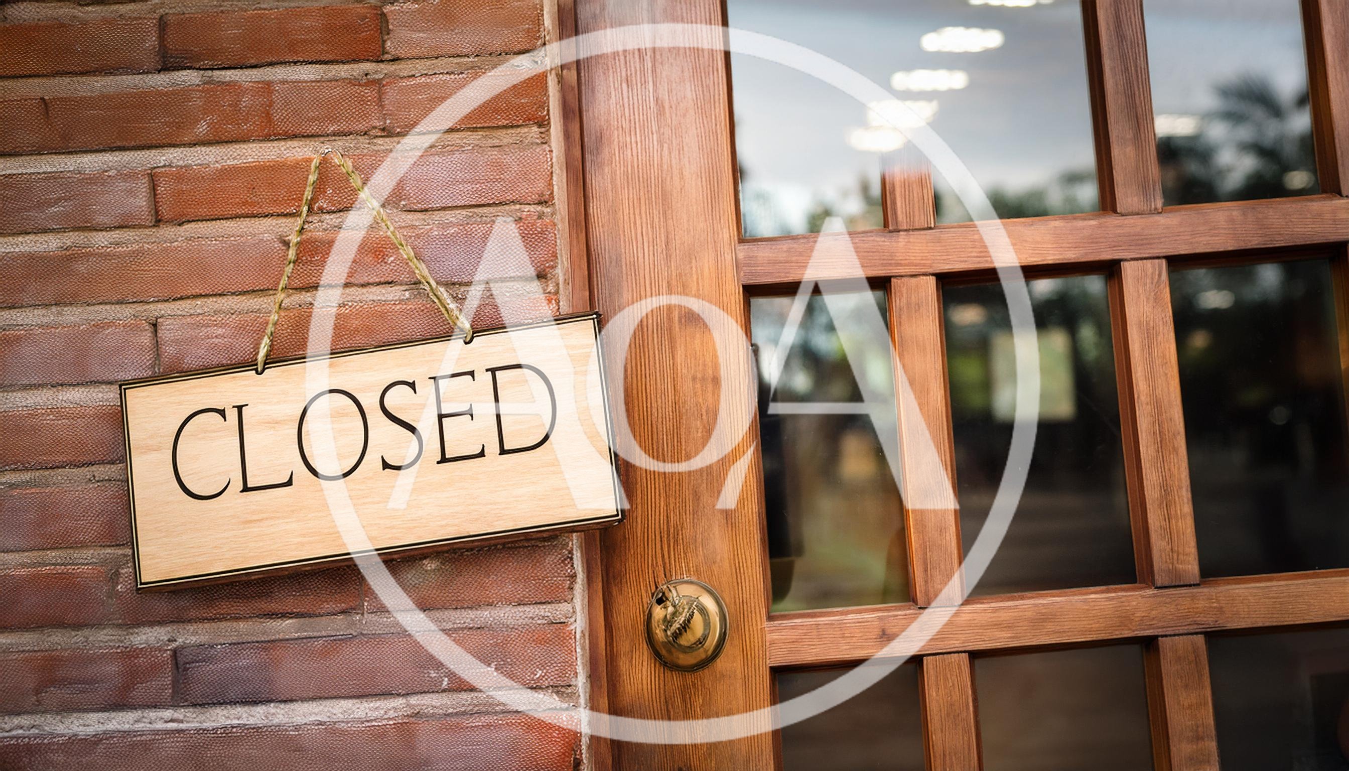 Closed Sign Hanging On A Wooden Door