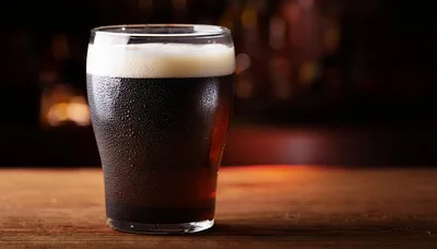 Cold Glass Of Dark Stout Beer On Wooden Table
