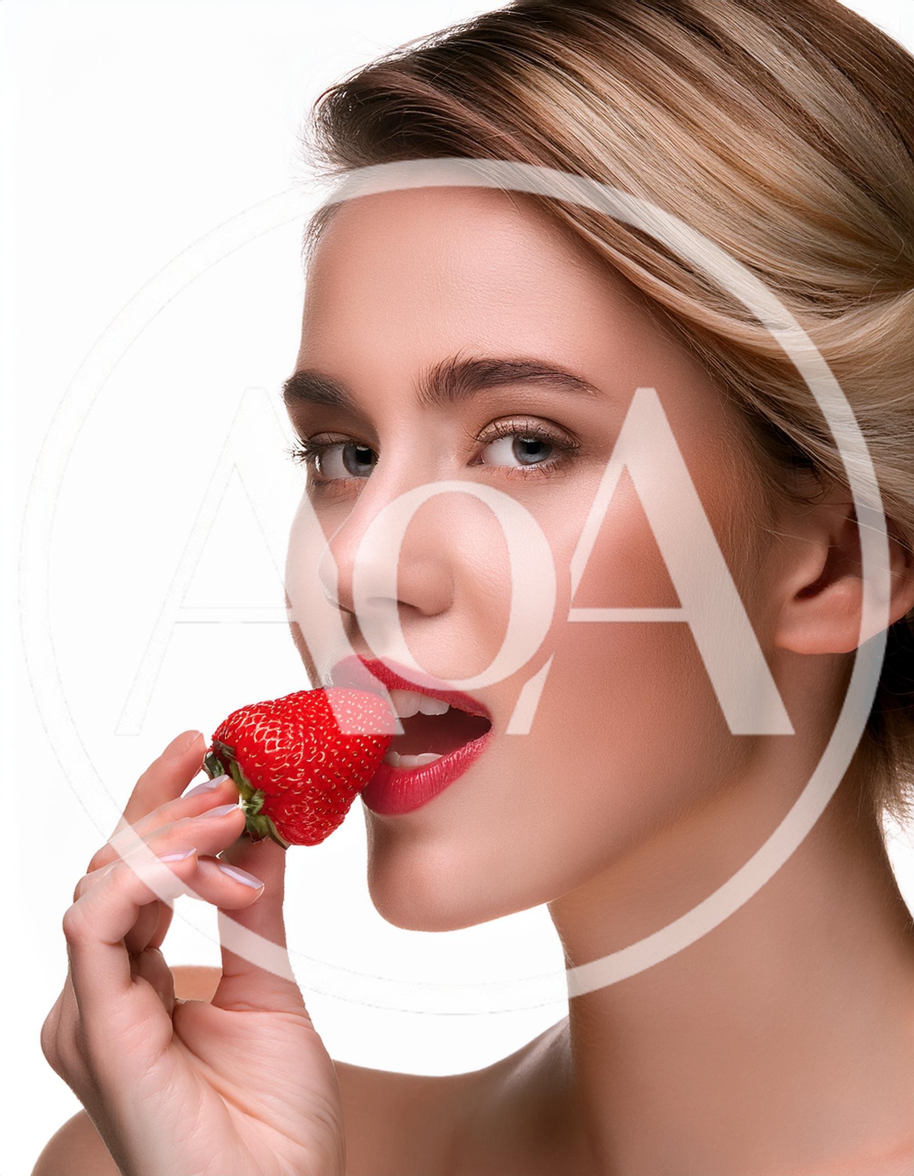 Beautiful Woman Holding A Fresh Strawberry To Her Lips