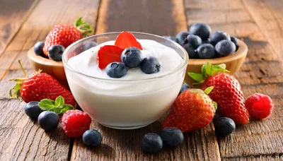 Bowl Of Yogurt With Fresh Berries On Wooden Table