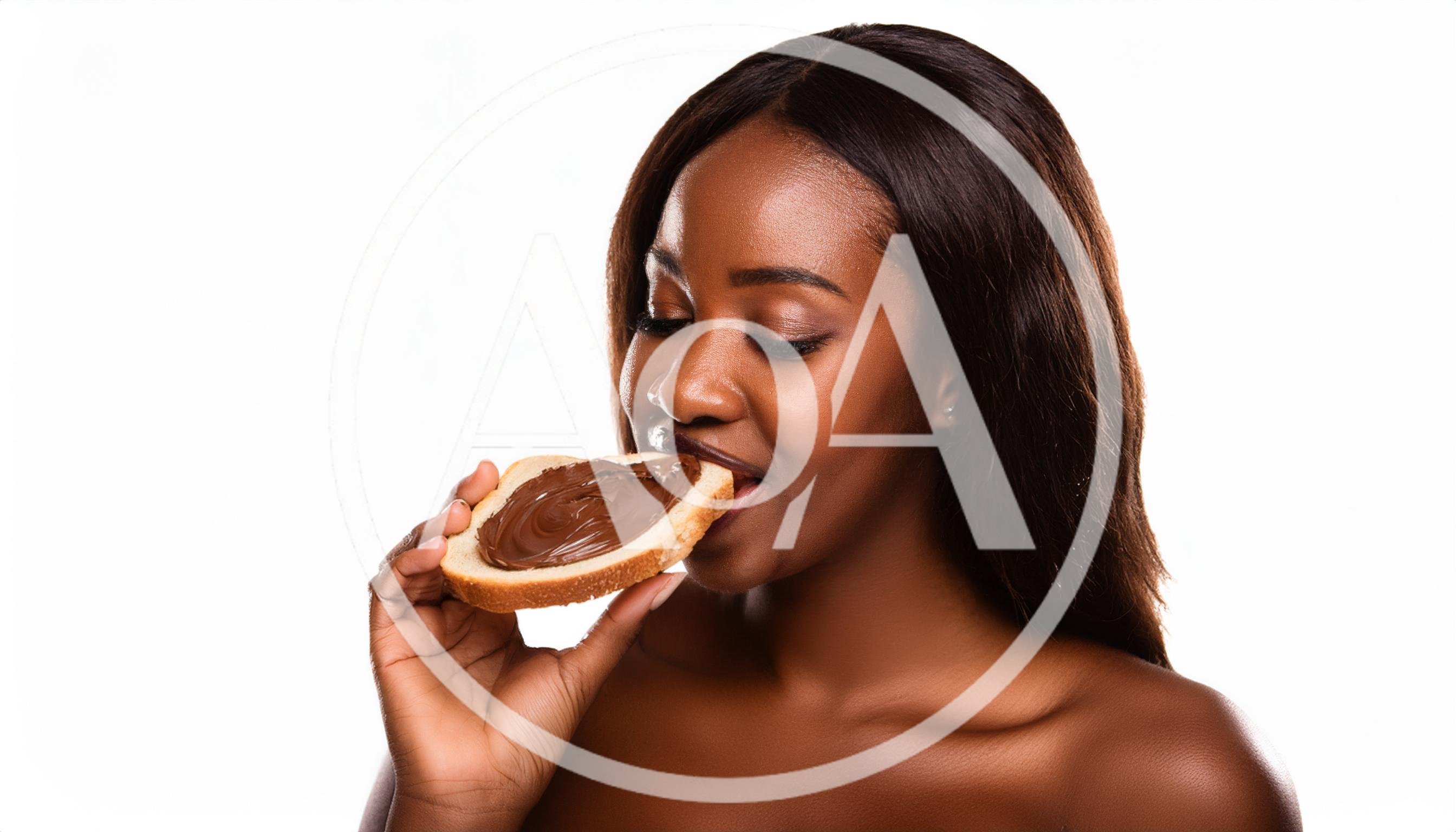 Young Black Woman Eating Chocolate Spread On Bread