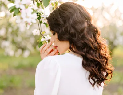 Woman Smelling Apple Blossoms in a Spring Orchard
