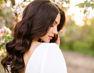 Beautiful Woman With Long Wavy Hair In Spring Garden