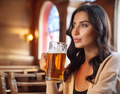 Young Woman Holding A Glass Of Beer In A Pub