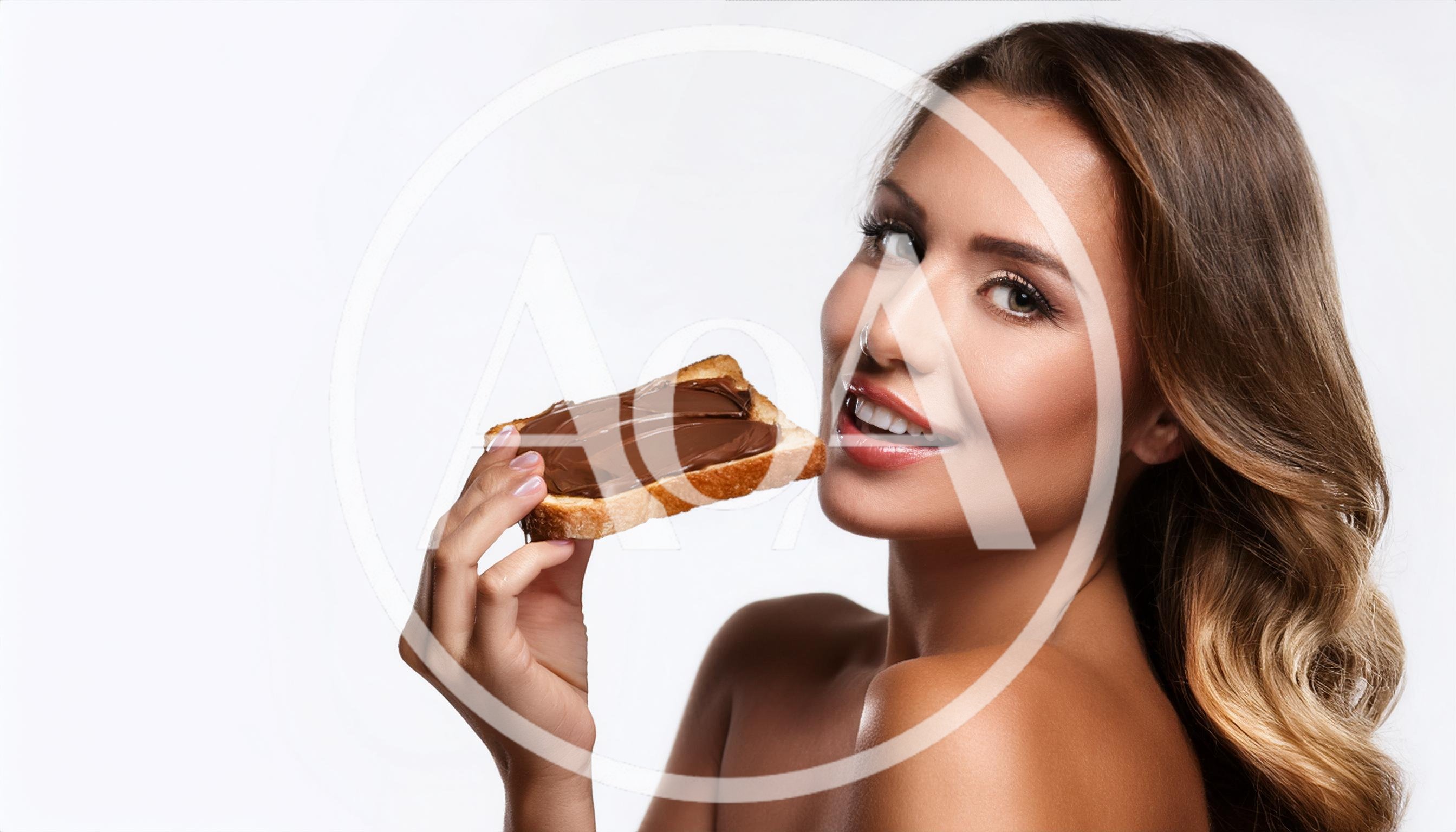 Beautiful Woman Eating Chocolate Spread On Toast