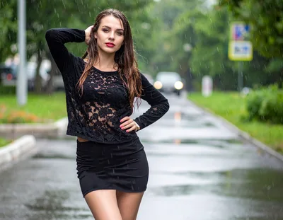 Young Woman Posing in Rain on City Street