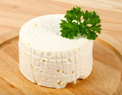 Fresh Round Cheese Wheel With Parsley Garnish