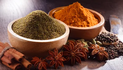 Assorted Spices And Herbs In Wooden Bowls