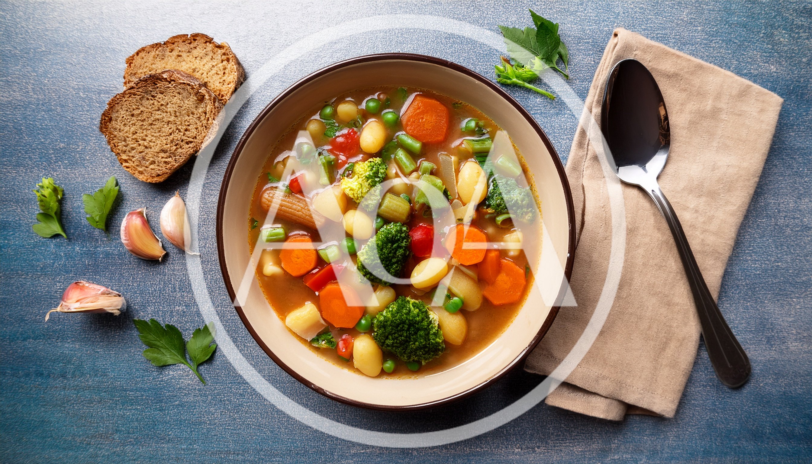 Bowl Of Vegetable Soup With Bread And Garlic